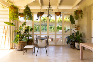 Indoor patio with hanging plants and wicker furniture, creating cozy atmosphere, copy space