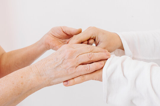 An older man holds the hands of a younger man