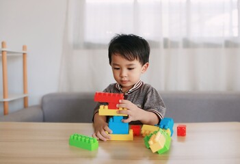 Little child plays with colorful toy blocks.  Educational and imaginative toys and games for young children.