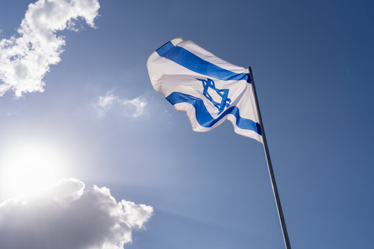 Israeli Flag Waving Against Sunlit Sky.
