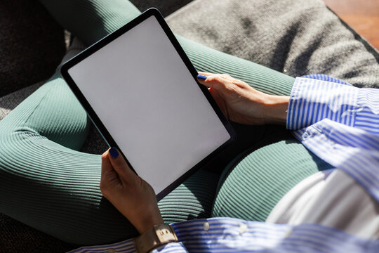 Pregnant woman is holding a tablet