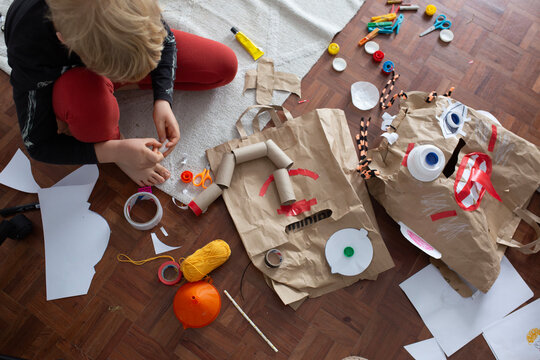 boy create monster mask  from paper bags 