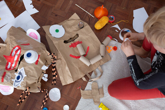 boy create monster mask  from paper bags 