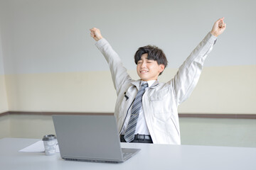 両手挙げる若い作業服男性