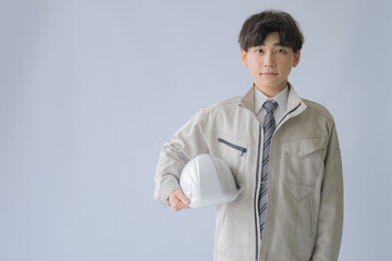 ヘルメットと若い作業着男性