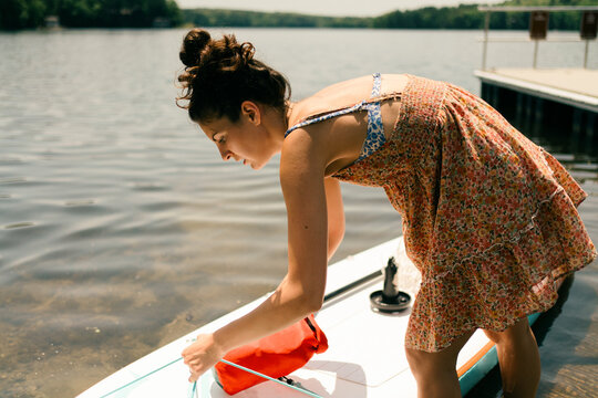 young woman getting ready to head out on her paddle board 
