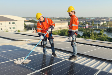 Electrical engineers team cleaning the solar panels on the building rooftop.