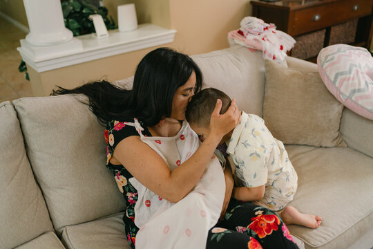 mother nursing newborn with toddler wanting affection