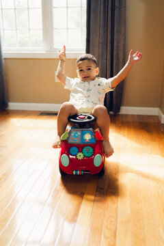 toddler playing on toy car 