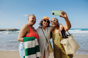 Senior women taking a selfie on a sunny beach day
