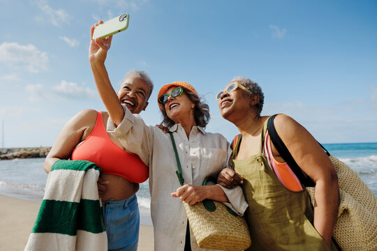 Senior friends enjoying a selfie at the beach