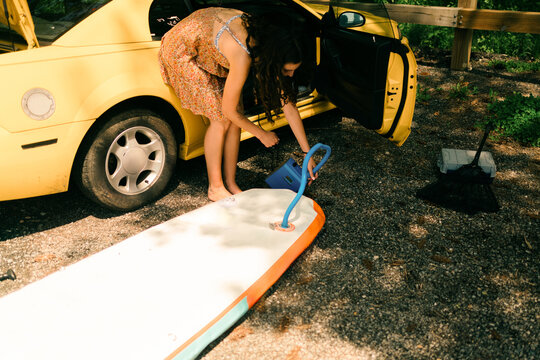 young woman inflating her paddleboard