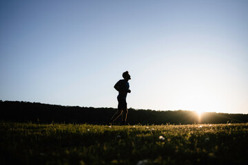 A man is jogging at sunset
