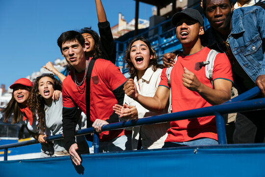 Enthusiastic fans cheering at a game in stadium