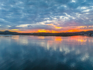 Sunrise over the bay water with clouds and reflections