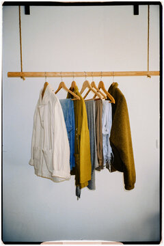 Small minimalist coat rack hanging from the ceiling with jackets