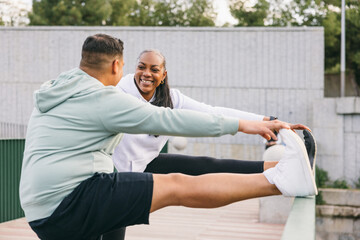 Dominican couple stretching legs at an outdoor park