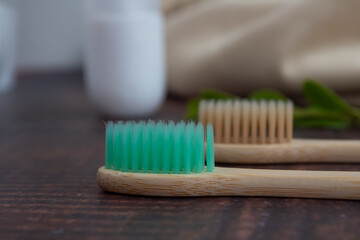 Pair of bamboo brushes on wooden table. Sustainable dental hygiene