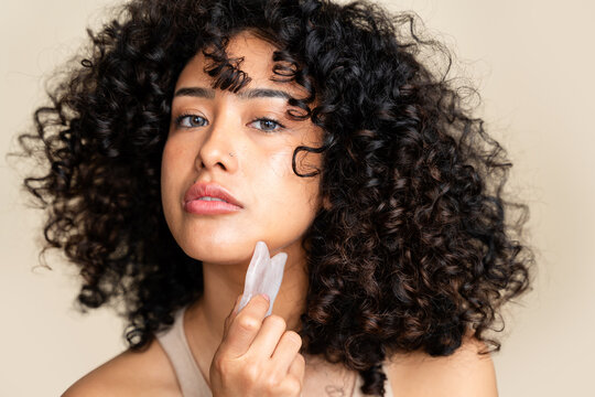 woman using gua sha facial massage tool