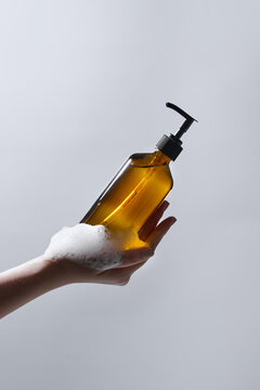 Woman with bottle of care product and cleansing foam