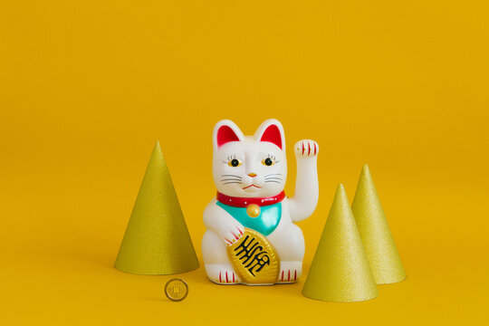 Chinese lucky waving cat with gold horns around it