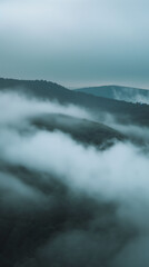 Serene Mountain Peaks at Dusk with Rolling Clouds and Warm Glow