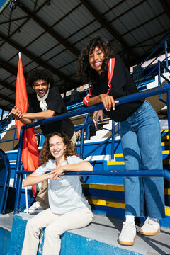 Joyful group of sports fans cheering in stadium stands