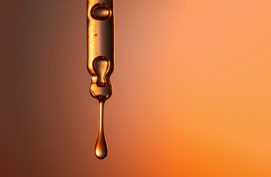 Clear glass pipette with a drop of cosmetic product falling down.  - Powered by Adobe