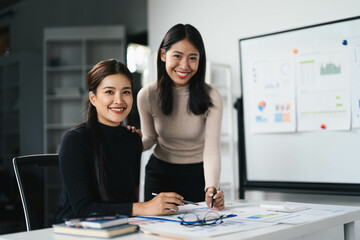 Professional Businesswomen Collaborating in Modern Office with Charts and Documents