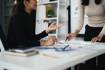 Collaborative Team Meeting in Modern Office with Two Women Discussing Business Plans and Documents