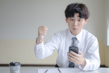 携帯と嬉しそうなビジネスマン
