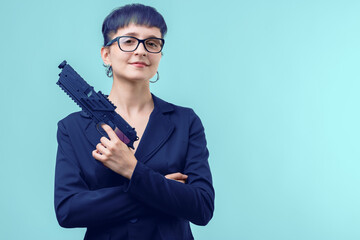 Businesswoman holding pistol posing on blue background