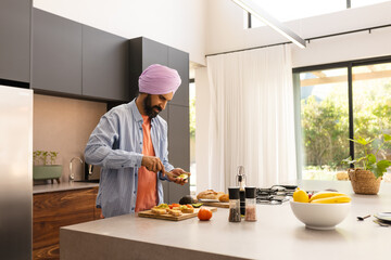 Preparing meal, man slicing vegetables on cutting board in modern kitchen, copy space