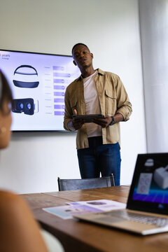 Presenting data, man holding tablet and explaining VR headset statistics in meeting