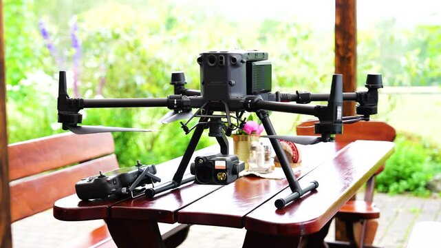 Large industrial drone with heavy camera payload on outdoor wooden table