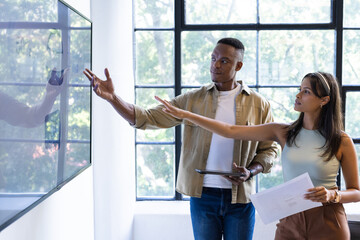 Presenting data on screen, colleagues discussing project in modern office setting, copy space