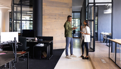 Business colleagues discussing work, using tablet in modern office setting, copy space