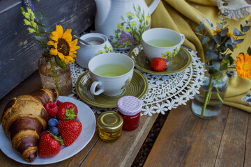 Morning summer tea with flowers and fruits on the veranda in the village house