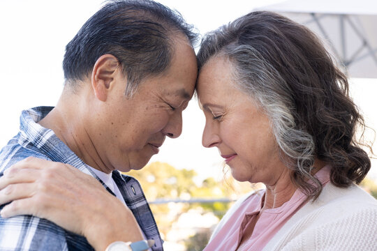 undefined and touching foreheads, senior couple sharing tender moment