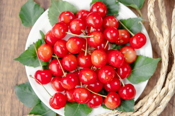 Close up shot Red Cherry fruit on wooden background, Japanese Red highest variety of Yamagata cherries on white table.