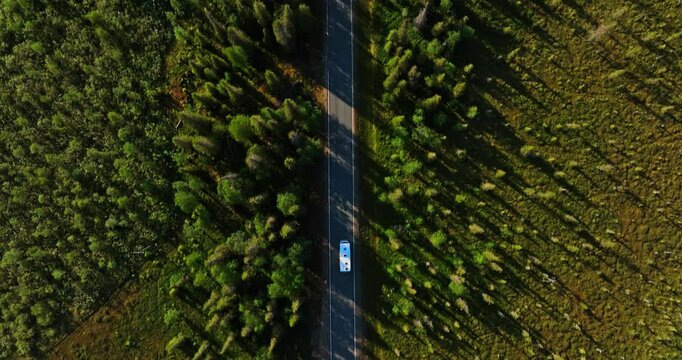 Top down drone shot above a RV passing arctic wetlands of Lapland, summer evening