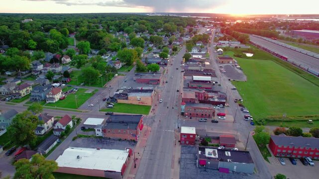 Aerial view of Silvis, Illinois, showing residential and commercial areas, roads, and greenery during sunset.