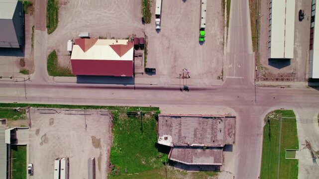 Top down three livestock trailers with trucks parked in an industrial parking lot. Iowa, USA. American flag.