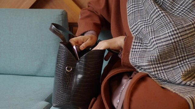 women looking for something in her purse