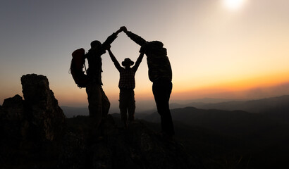 silhouette male and female hikers climbing up mountain cliff . helps and team work concept. unity and success.