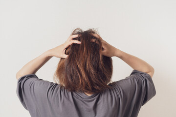 頭を抱える女性の後ろ姿