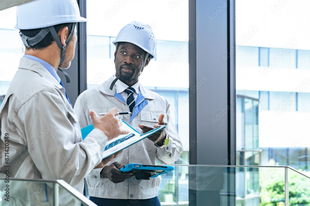 Poster group of multinational engineers having a conversation in a facility