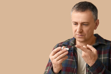 Mature man with contact lens and case on brown background