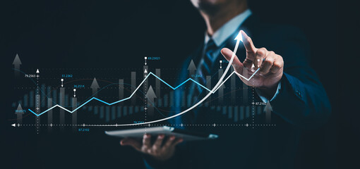 A businessman analyzing the economic growth graph for investment growth touches on concepts of interest rates and dividends, highlighting the interconnections between business financial investment