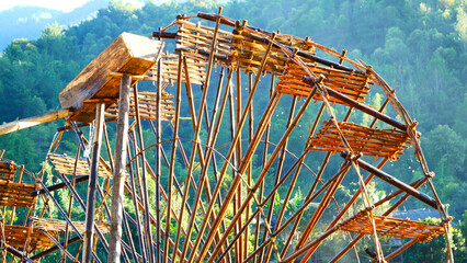 Wood water wheel Baler Machine in Agriculture Farm impeller lifted pumping water in river. Wooden Water Baler Machine green garden Farm blades by windy natural. Sustainable Resources Environment © aFotostock